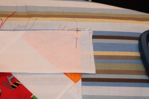 After Steam-easing: Border strip extends past the raw edge of the quilt top and the quilt lays flat.